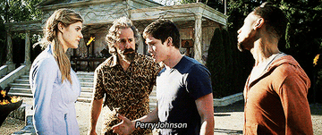 Stanley Tuchey as Mr. D and Logan Lerman as Percy Jackson walking together while Percy&#x27;s friends leave them alone. They are outside with a stone building behind him