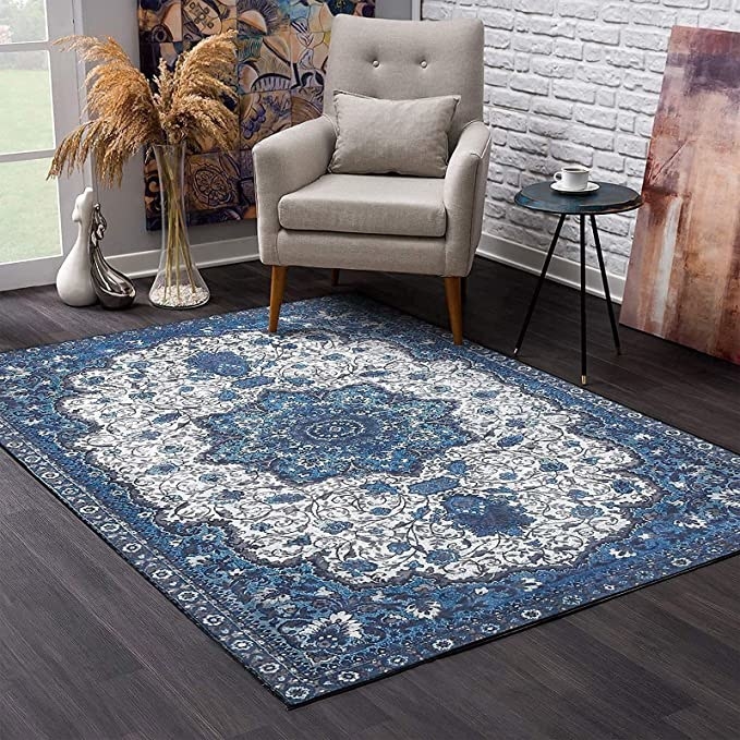 An area rug in a living room with wooden floors and a trendy chair