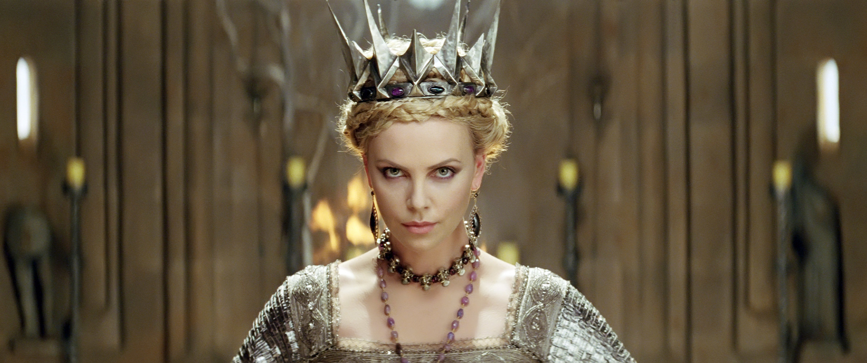 balancing a heavy crown on her head, the queen glares into the camera