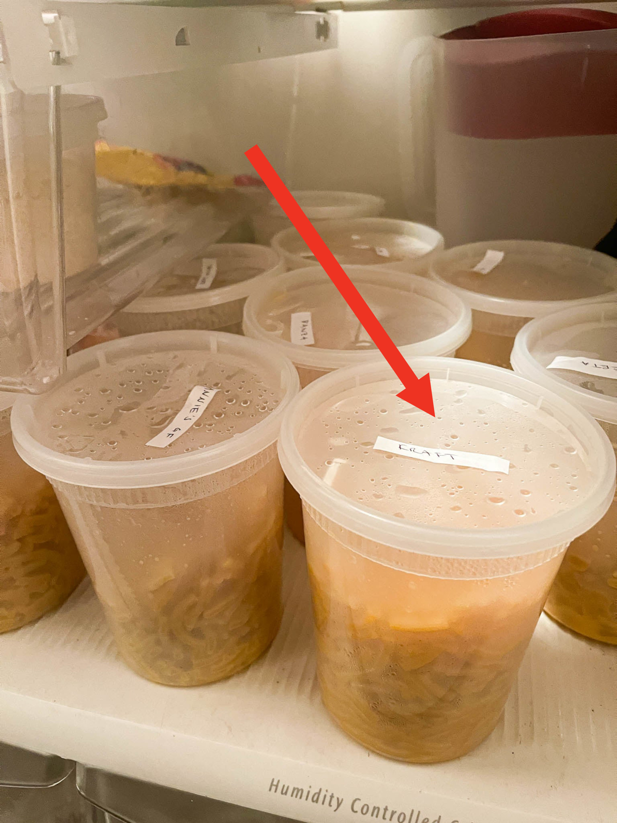 Arrow pointing to the author&#x27;s fridge full of mac &#x27;n&#x27; cheese in individual plastic containers