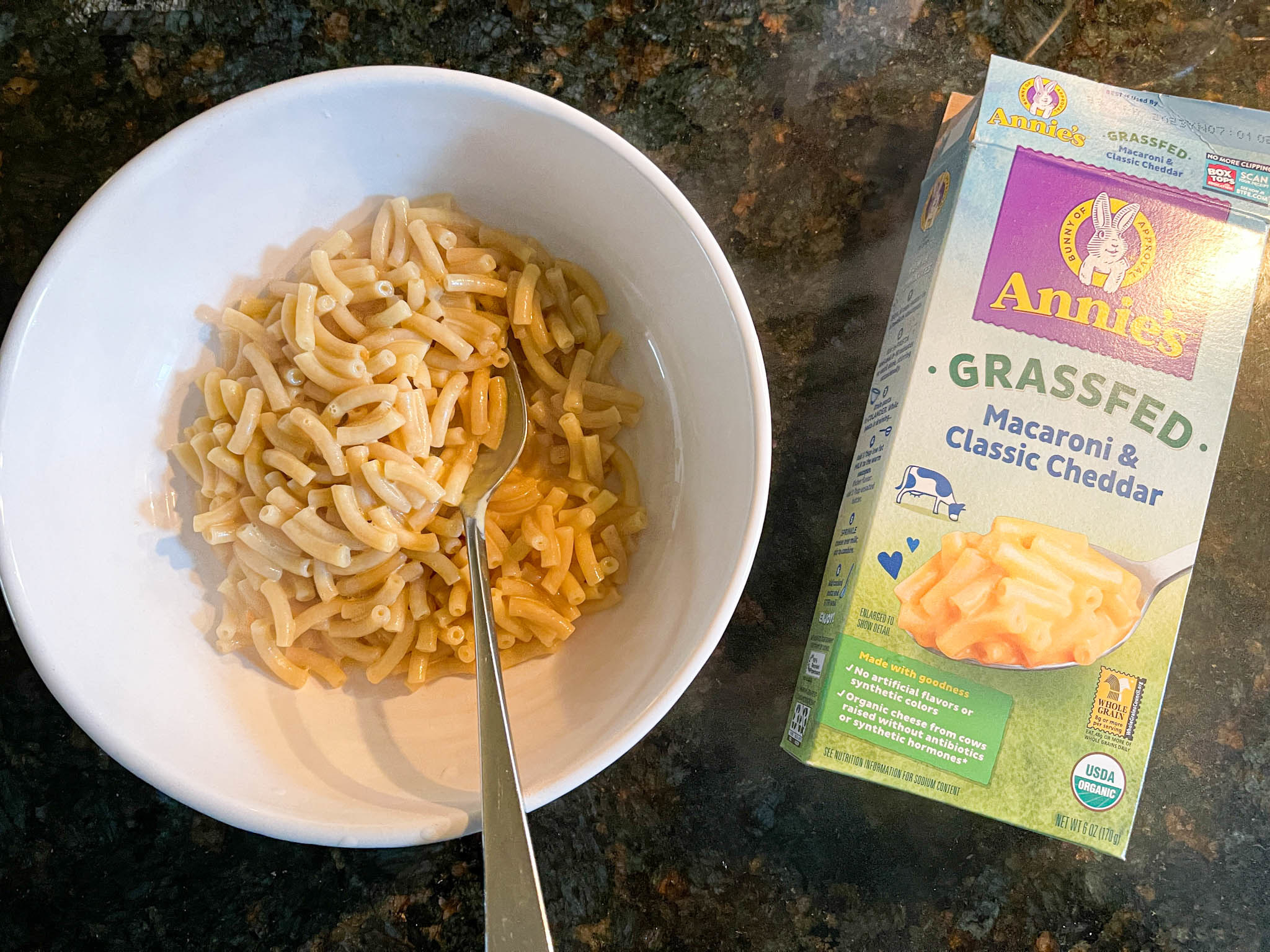 Cooked Annie&#x27;s Grassfed mac &#x27;n&#x27; cheese next to its packaging