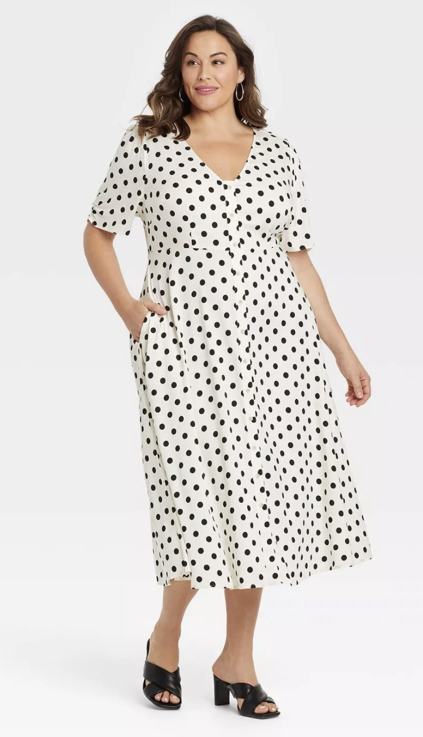 model wearing the dress in white with black polka dots