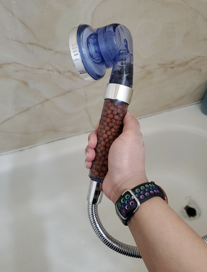 reviewer holding shower head