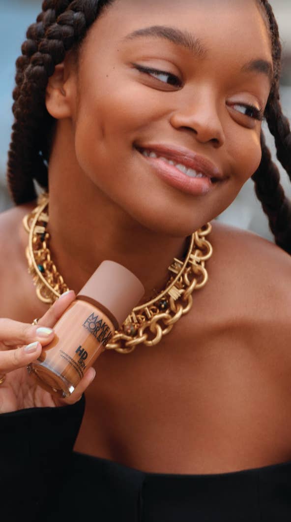 Woman holding a bottle of HD Skin foundation