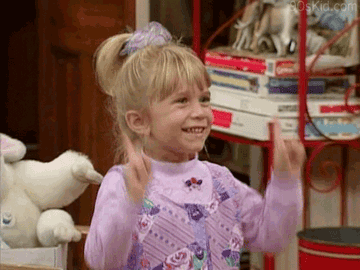 A gif of Michelle from Full House doing a little happy dance