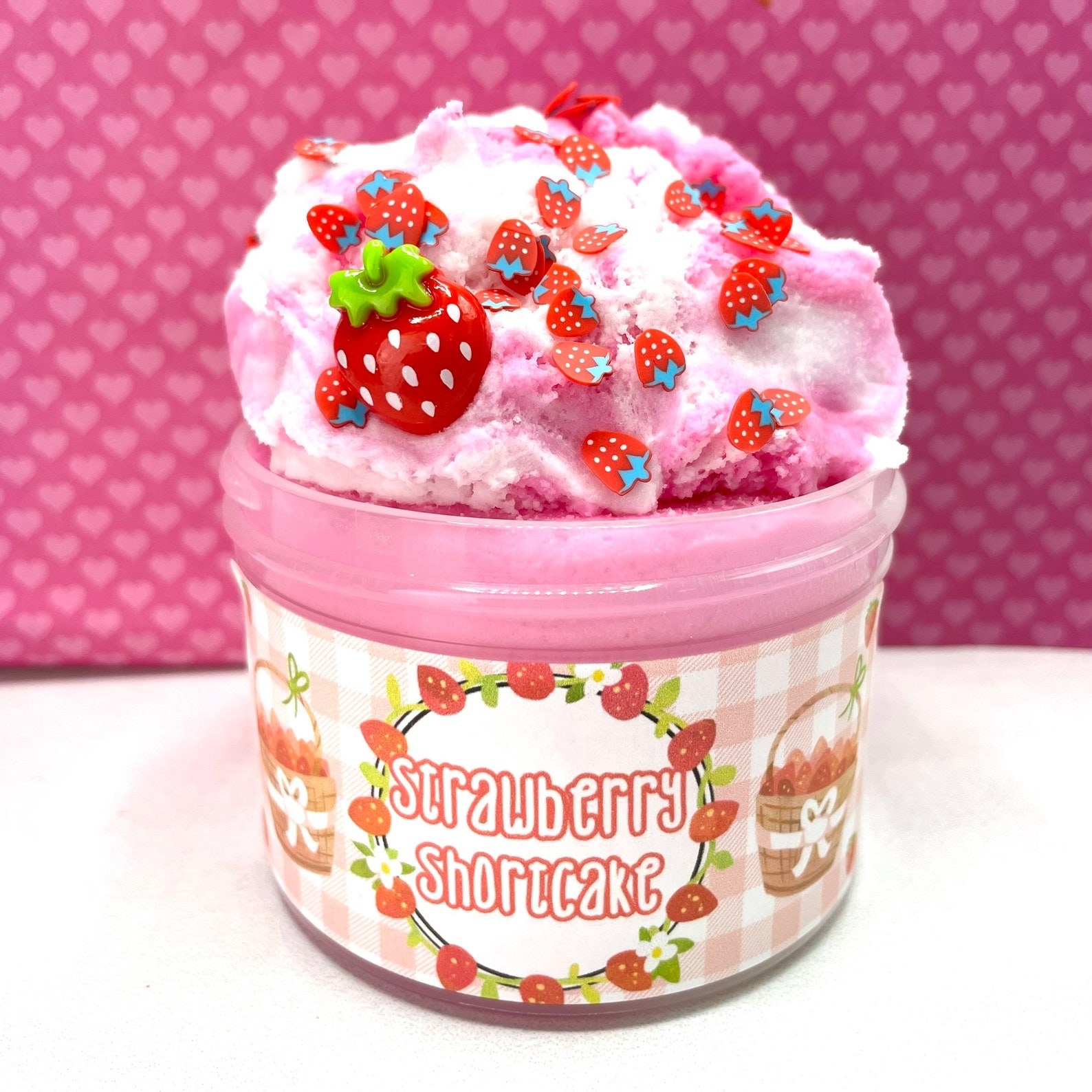 A pink colored jar of strawberry shortcake slime