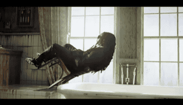 Lil&#x27; Wayne falling backwards in a chair for a music video