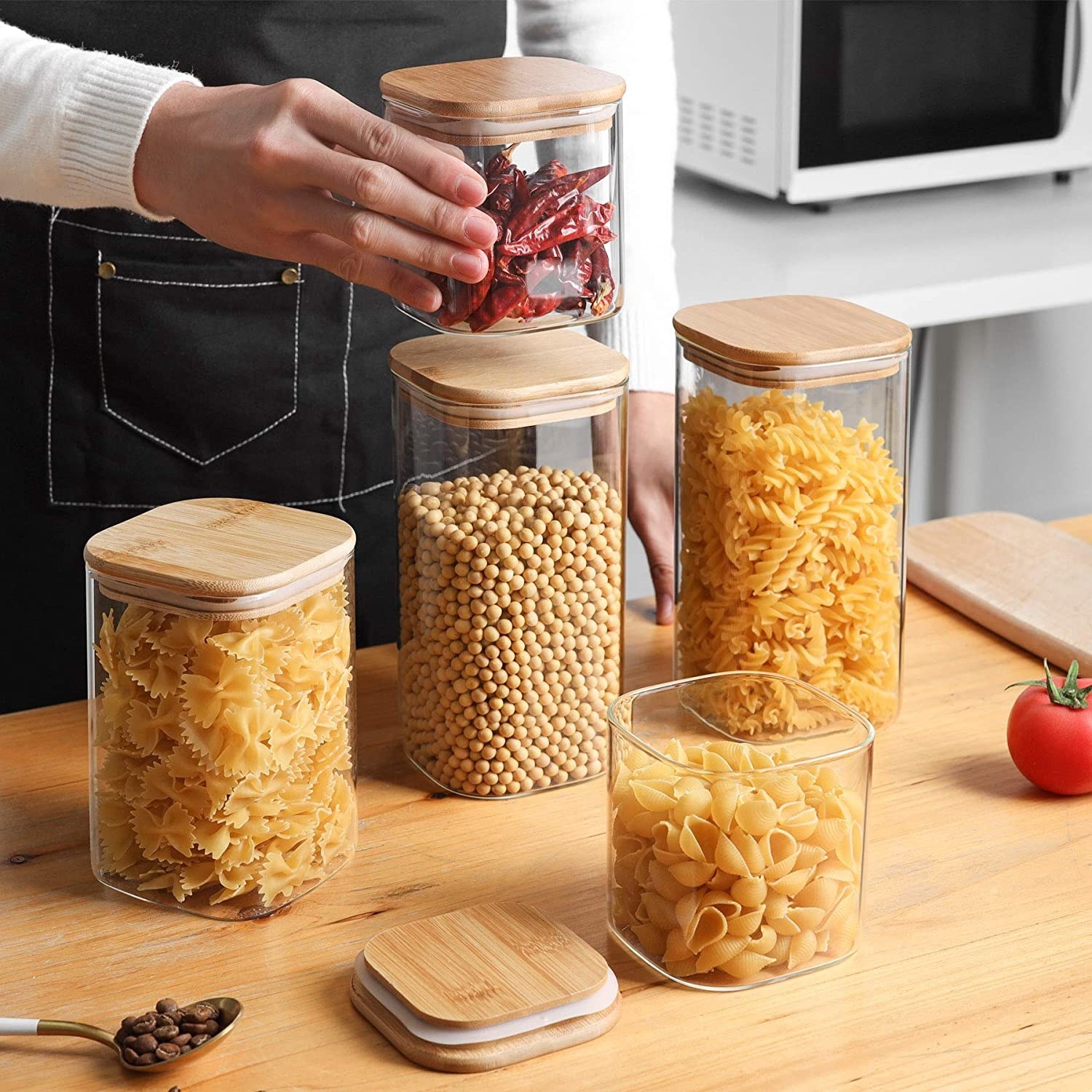 Several jars filled with pasta and grains on a counter