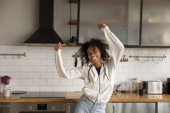 Young woman dancing in her kitchen at home