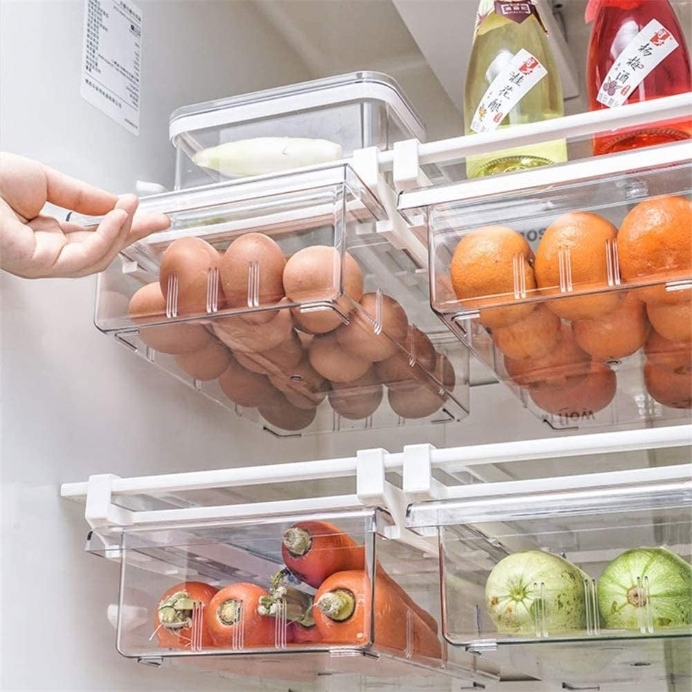 four drawers attached to fridge shelves to clasp  eggs and different   veggies