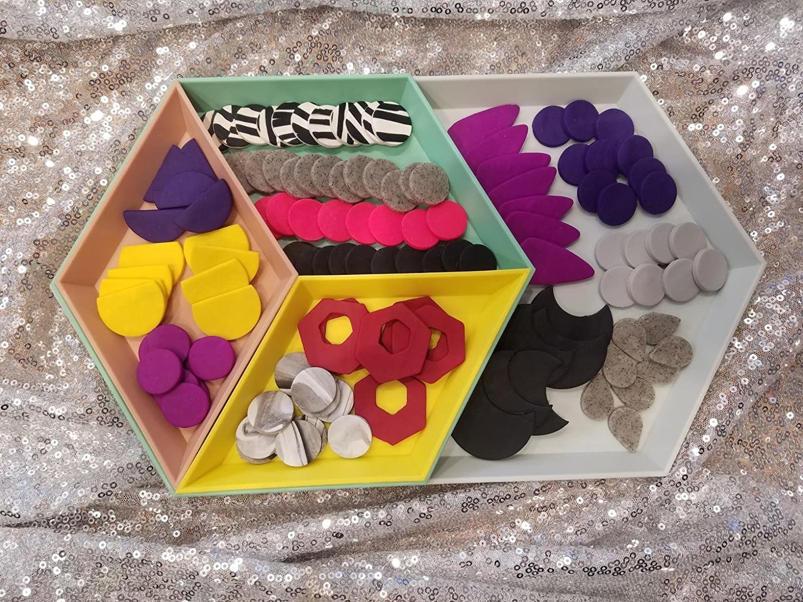 a reviewer photo of the different-colored nesting trays filled with clay pieces