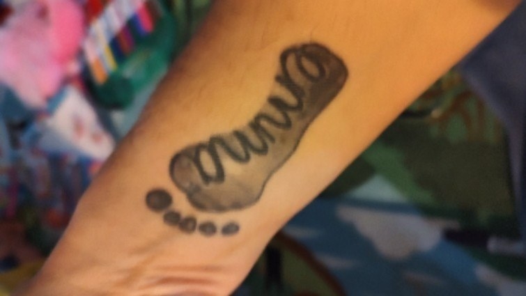 tattoo of baby foot with the name &quot;emma&quot;