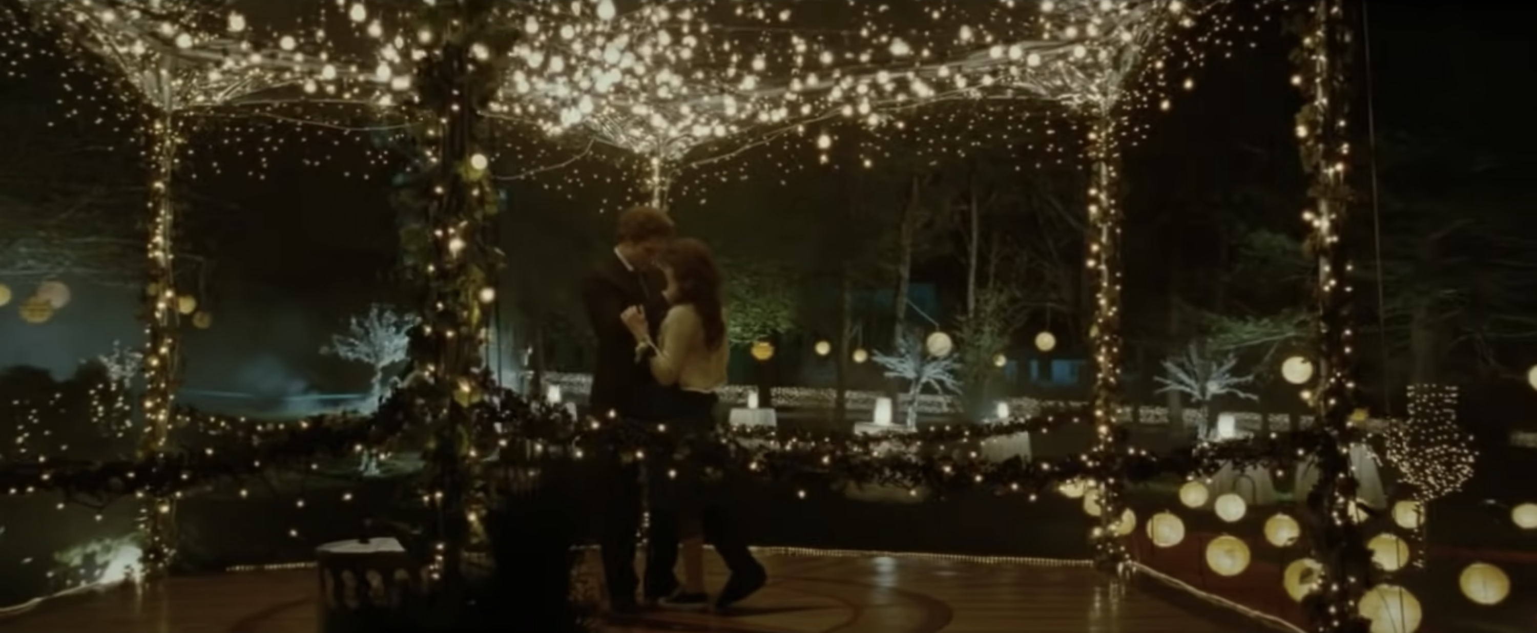 Robert Pattinson as Edward and Kristen Stewart as Bella dance under a gazebo wrapped in string lights during prom in &quot;Twilight&quot;