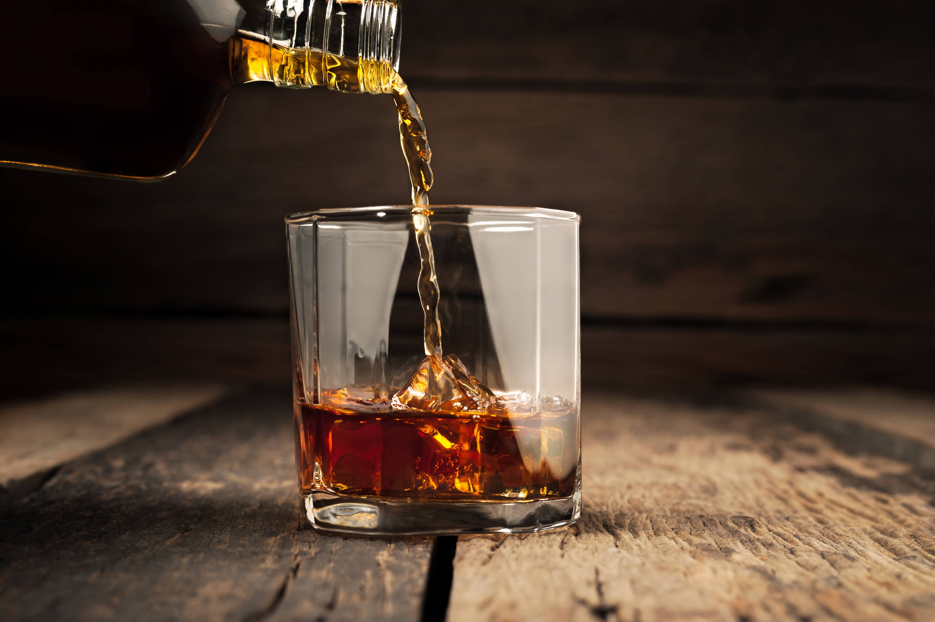 A bottle of alcohol being poured into a glass