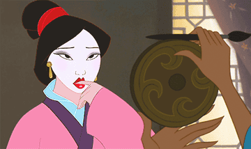 Mulan pulls a strand out of her bun to place on her forehead