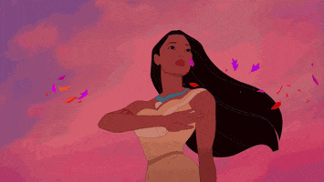 A close up of Pocahontas as she waves while leaves fly past her