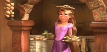 Rapunzel balances multiple plates of cookies on her arms and head