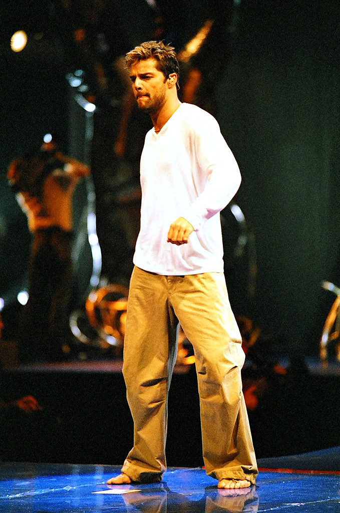 Ricky martin performing in long khaki pants