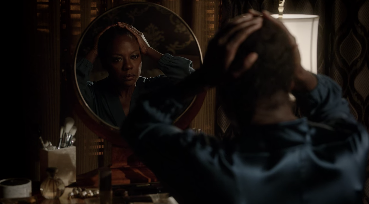 Annalise rubs her head after taking off her wig