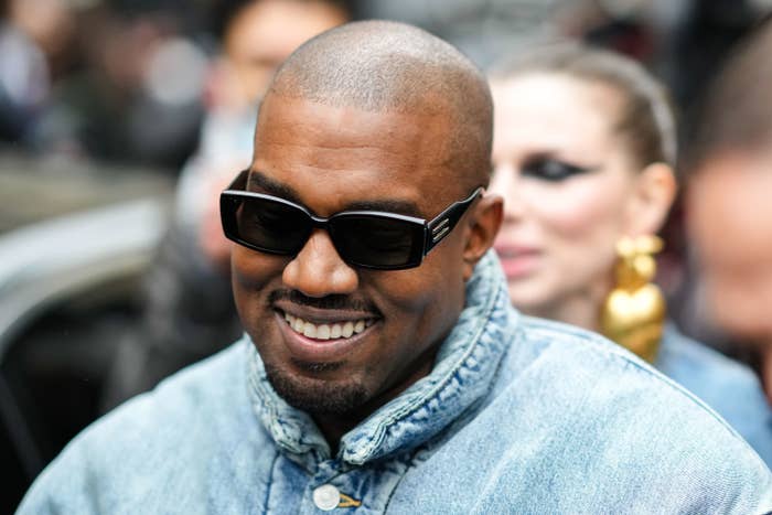 Photograph of Kanye West smilng with sunglasses on