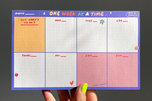 hand holds up a small planner that says one week at a time with room for each day of the week plus an area for this week's to-dos