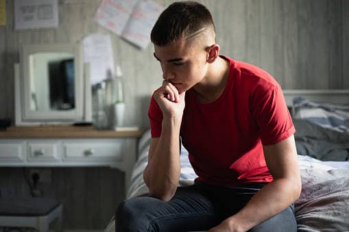 Young man leaning on hand in thought