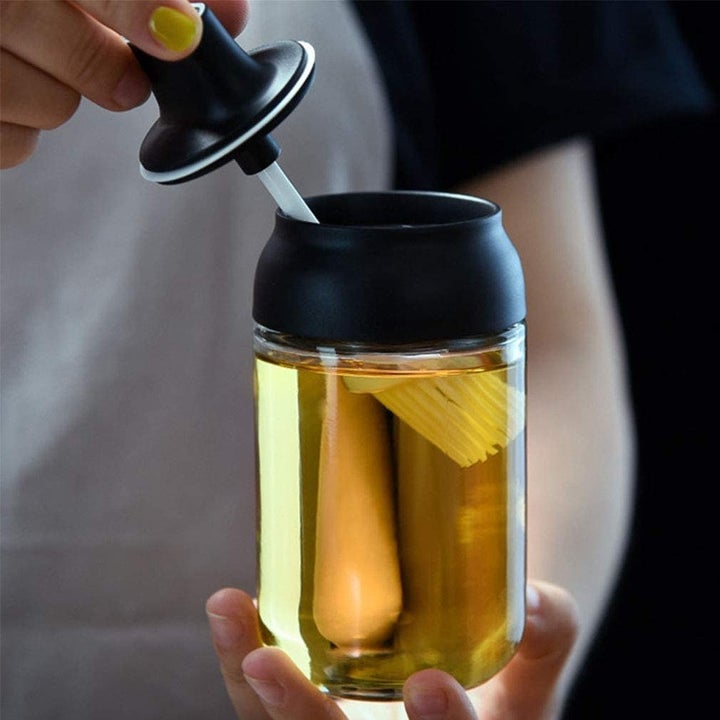 someone dipping the silicone brush into the cruet