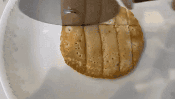 A gif of a pizza cutter cutting a pancake into bite-size pieces