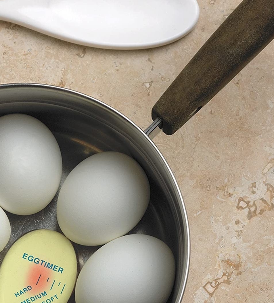 a colour-changing egg timer inserted into a pot of boiling eggs