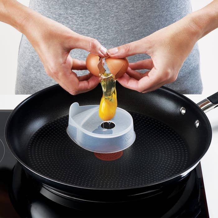 a person using the silicone pods to fry an egg on a frying pan