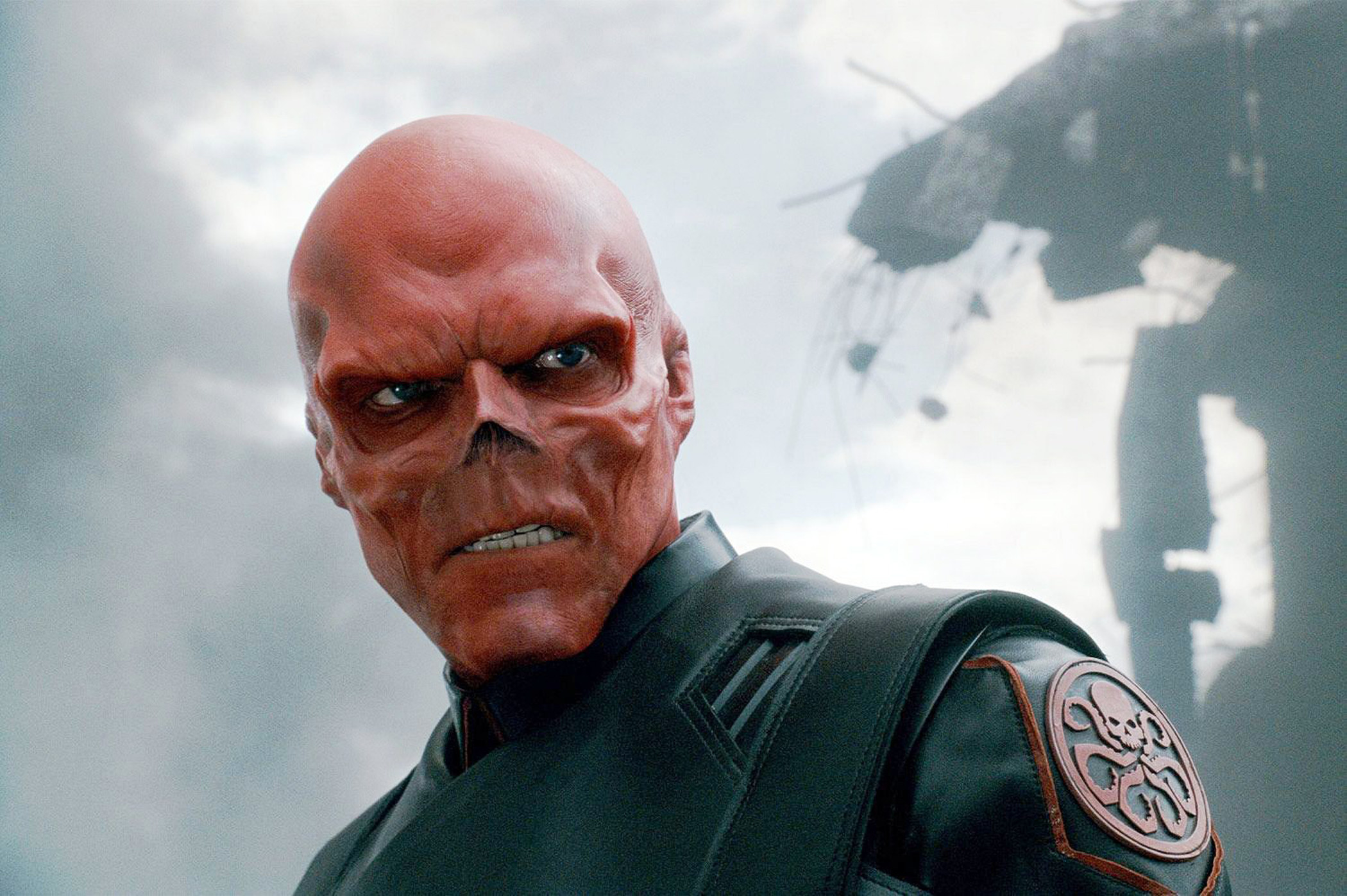 wearing his Hydra-branded jacket, Red Skull glares as his lab explodes behind him