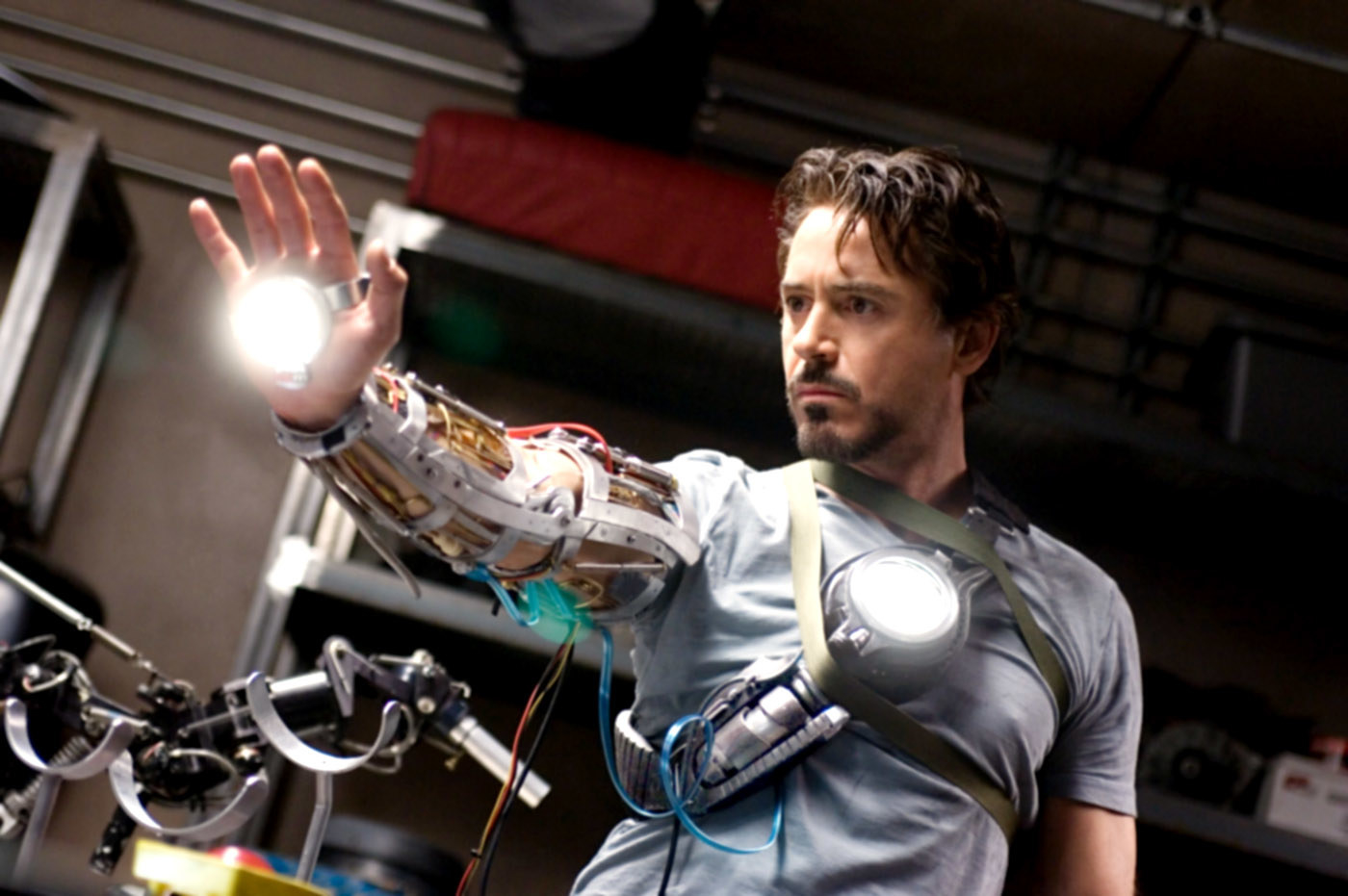 in his workshop, Tony tests out a prototype for his Iron Man suit arm