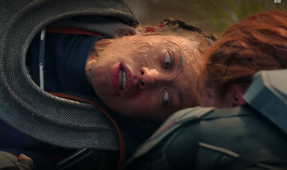finally free, Taskmaster lays on the ground while Natasha crawls to her to comfort her