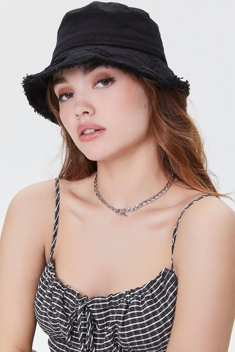 a model wearing a black bucket hat