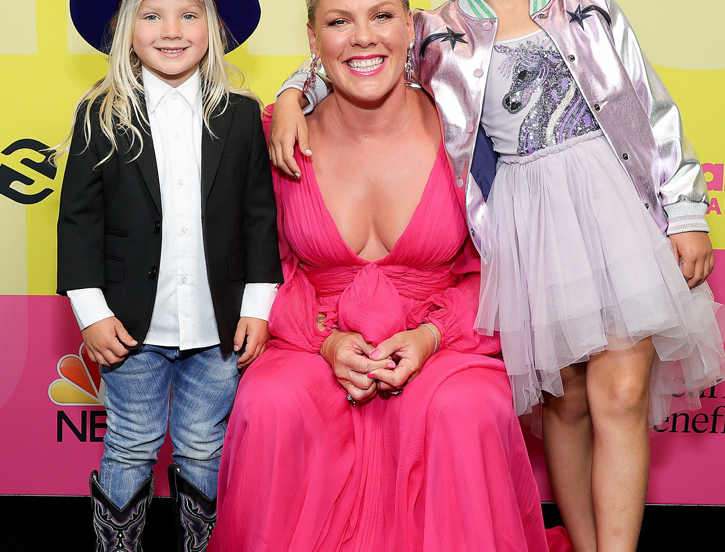 粉红色的姿势和她的两个孩子在一个粉红色的地毯