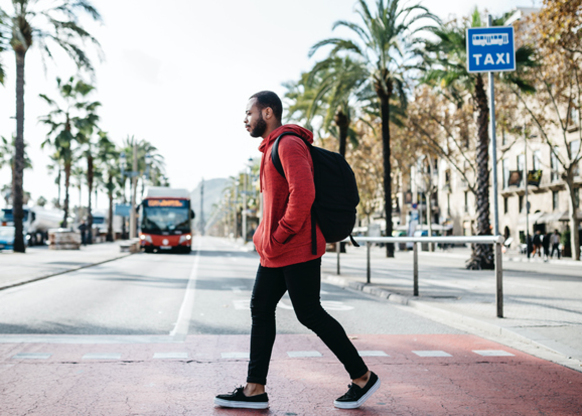 Black person walking with a hoodie with the hood off