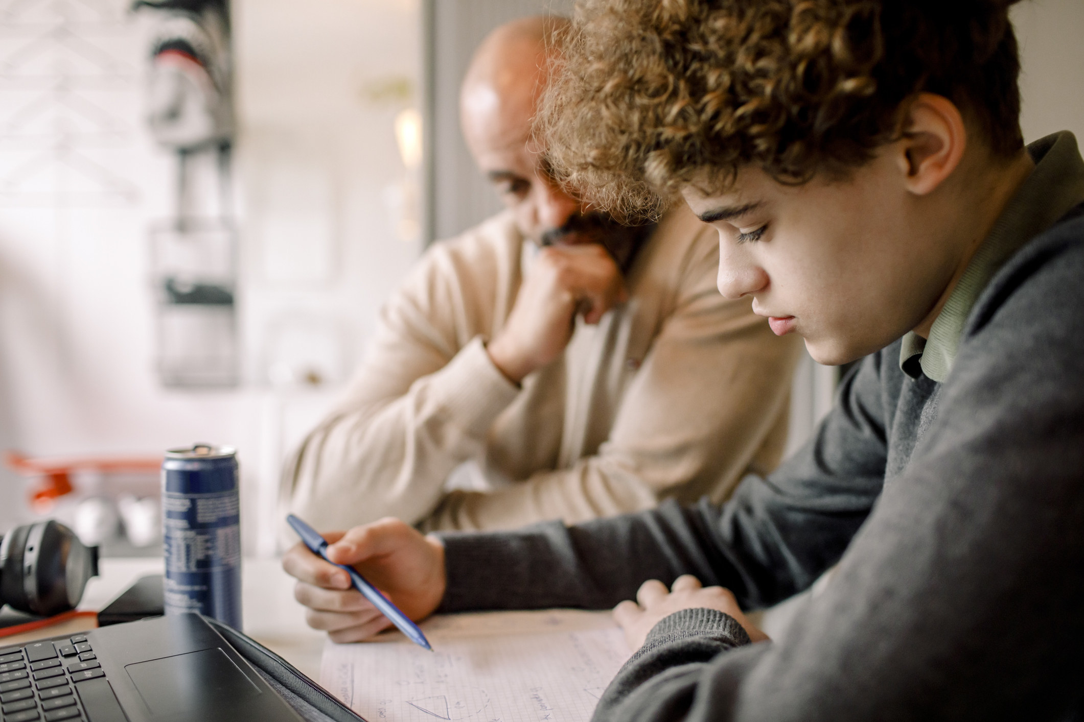 A dad helps his teen son with homework