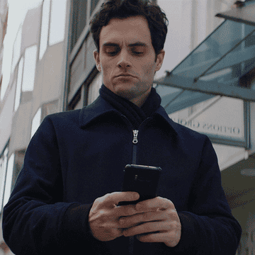 A man looks at his phone with concern