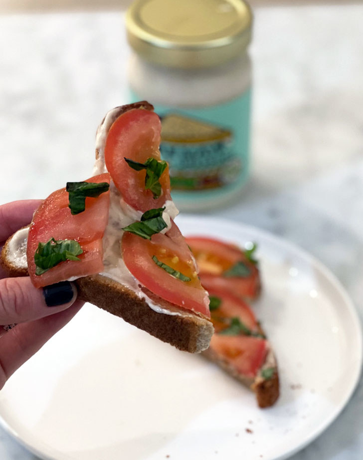 A slice of toast with mayo and tomatoes.