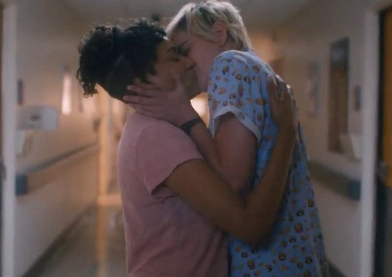 A couple shares a passionate kiss in the hospital hallway