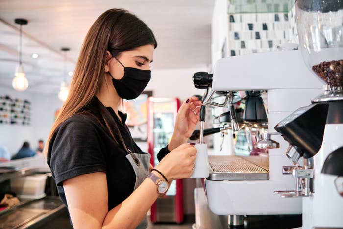 A coffeeshop barista making a coffee