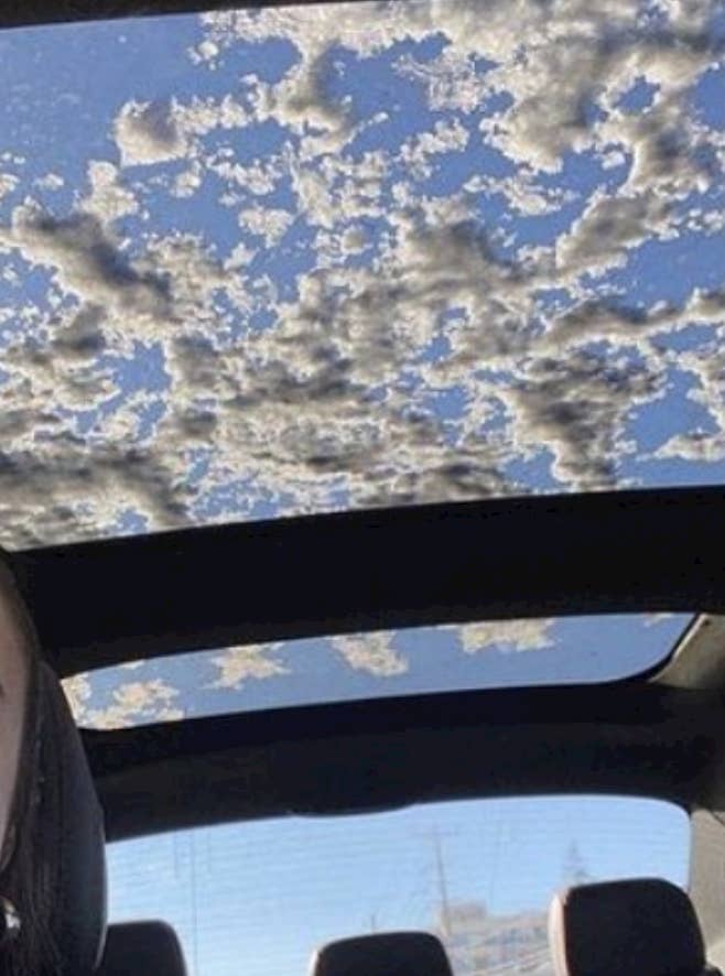 Snow on a car sunroof that looks like clouds