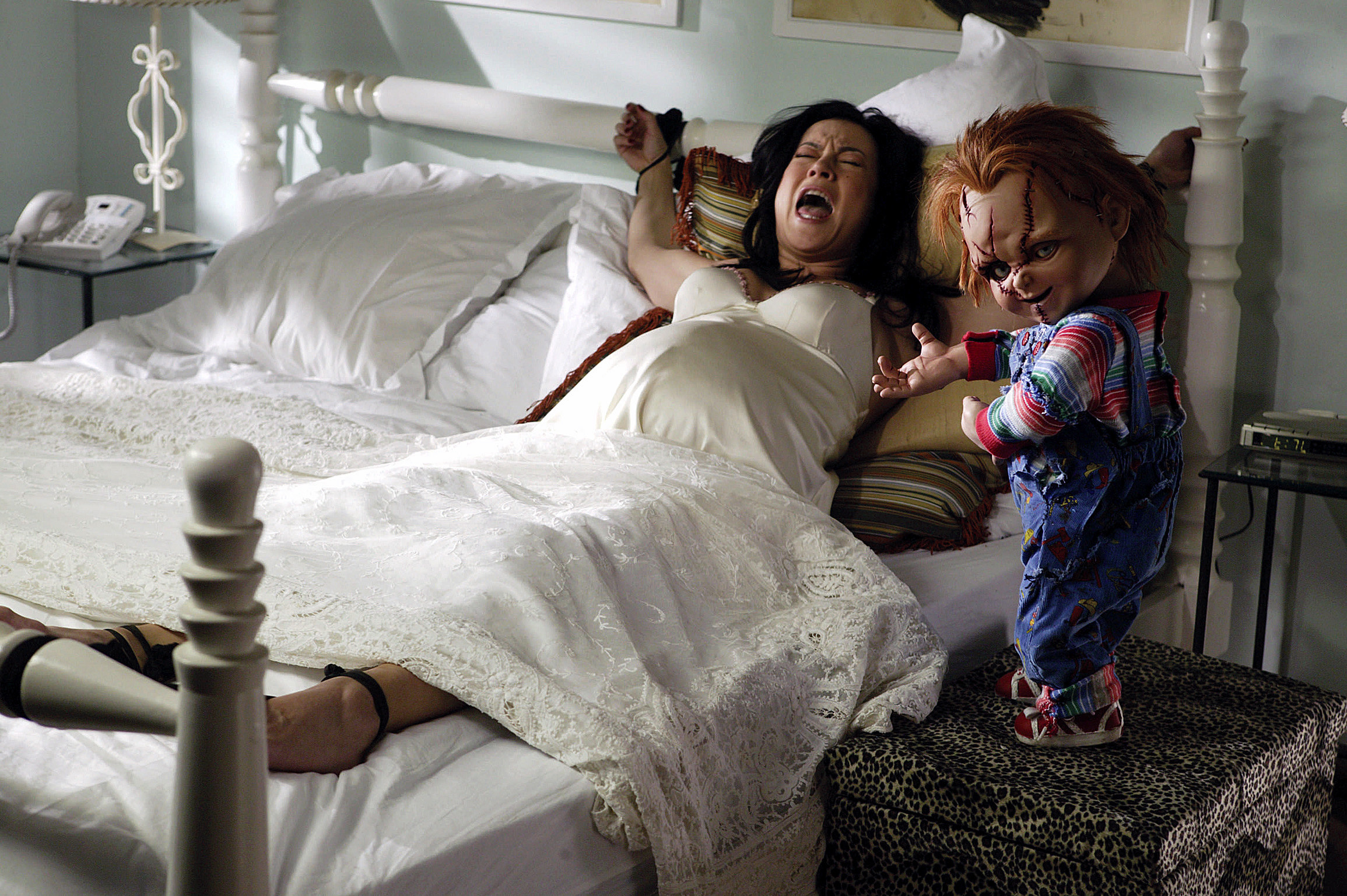 Chucky next to a woman screaming and tied to a bed in &quot;Seed of Chucky&quot;