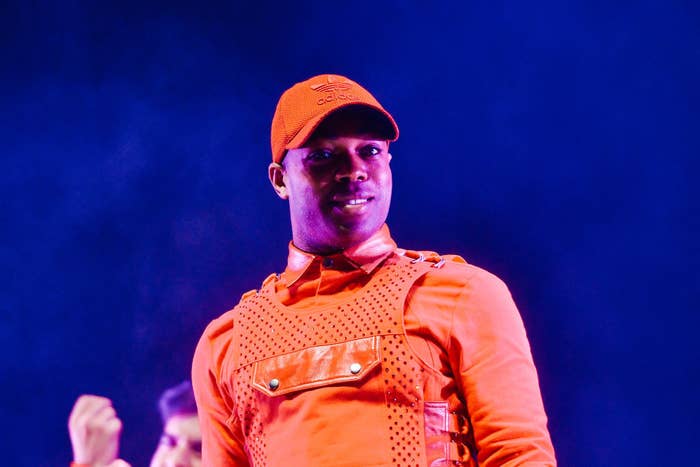 Todrick on stage in an orange outfit