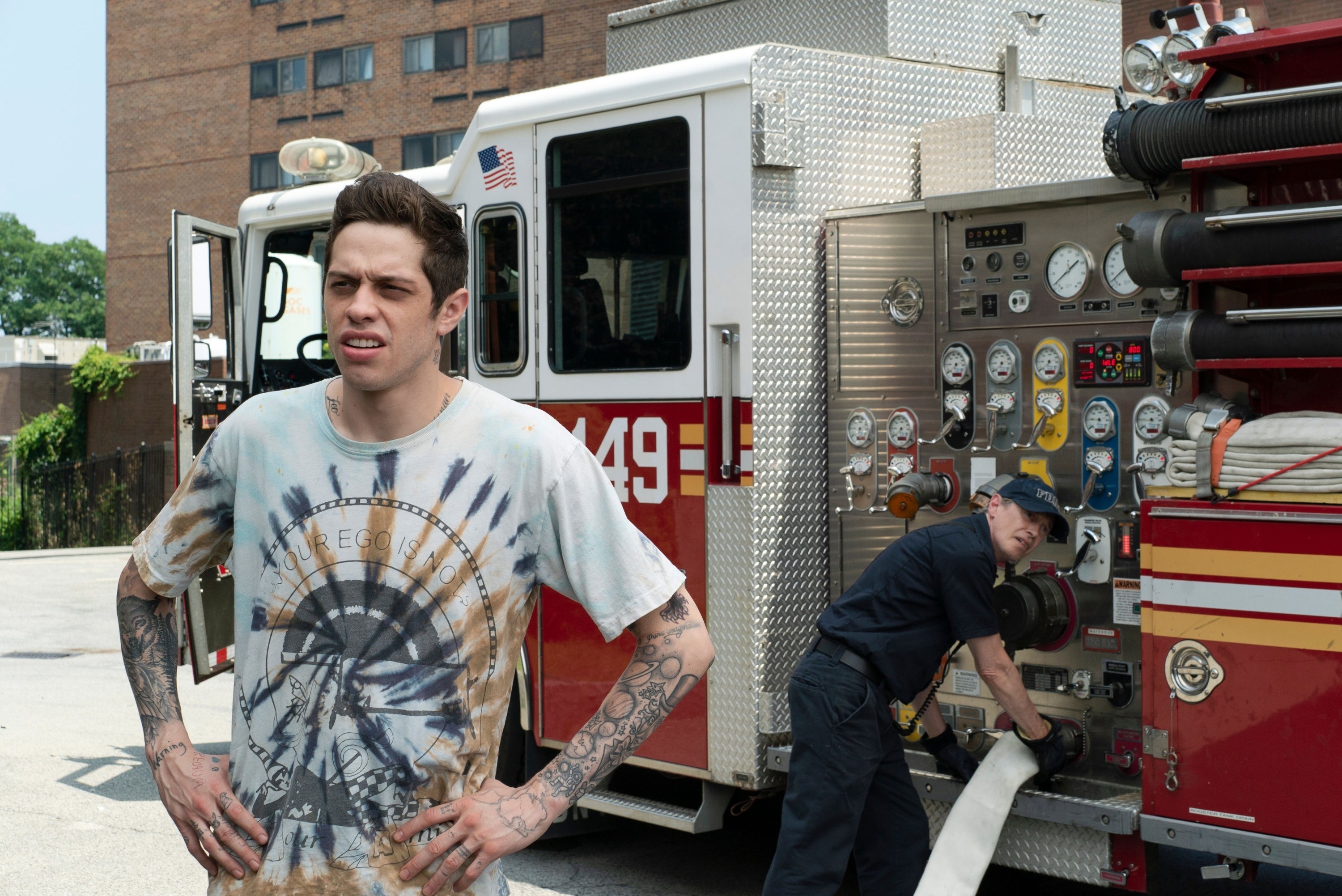 Pete Davidson in front of a fire truck. 