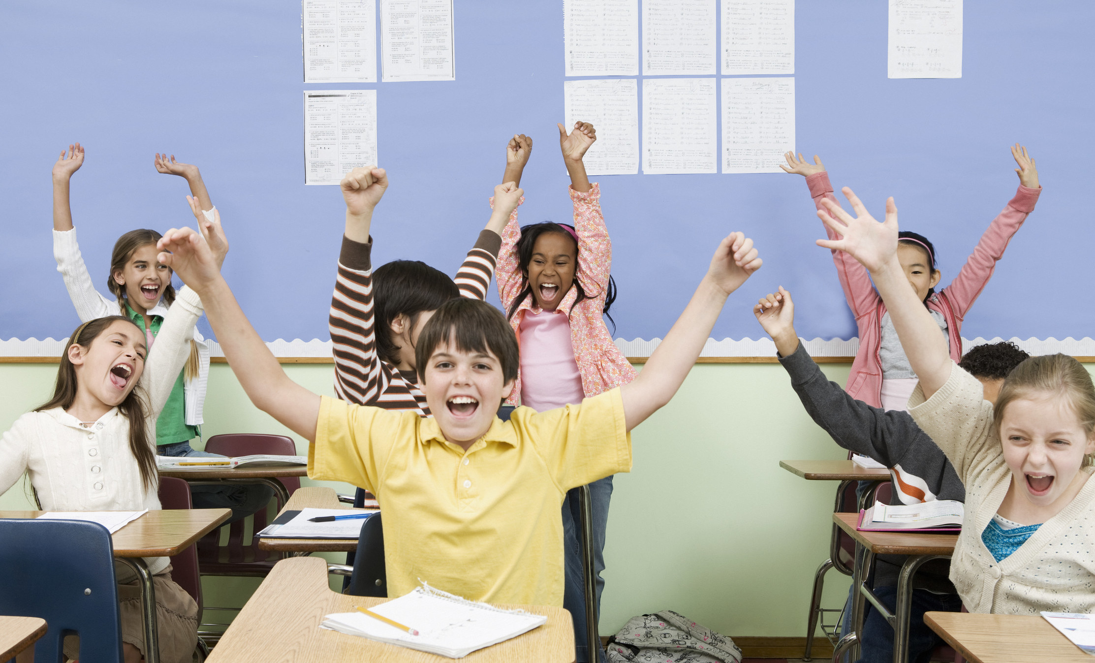 Young students in classroom cheering