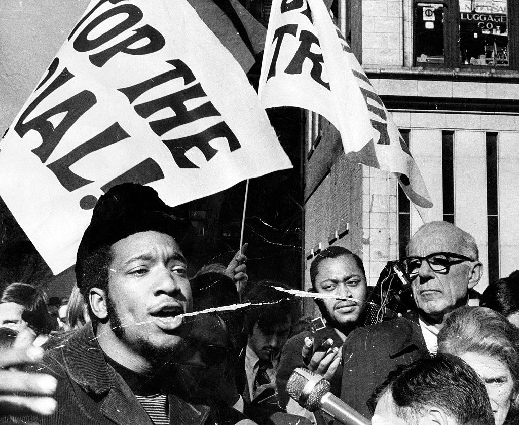 Fred Hampton, left, head of the Illinois Black Panthers, and Dr. Benjamin Spock, right, attend a rally against the trial of eight people accused of conspiracy to start a riot at the Democratic National Convention
