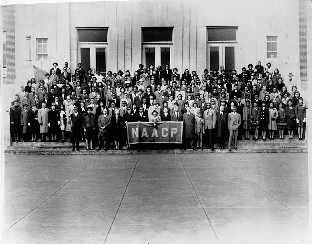 A large group of the 6th Annual Youth Conference of the NAACP poses on the step of a building