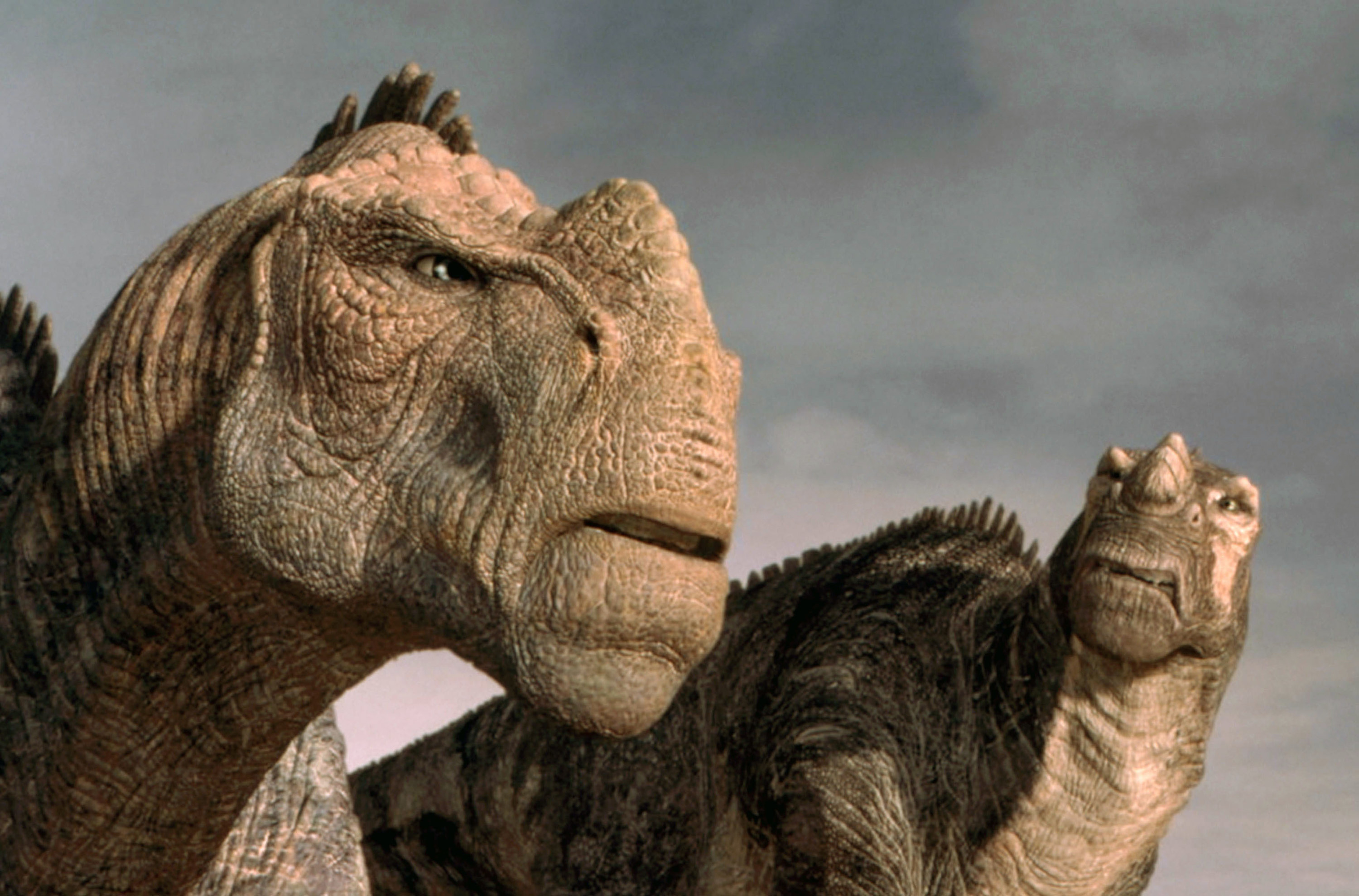 Two CGI dinosaurs from the movie looking at each other angrily