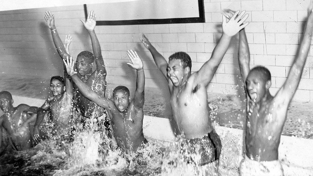 Black children jump in a pool
